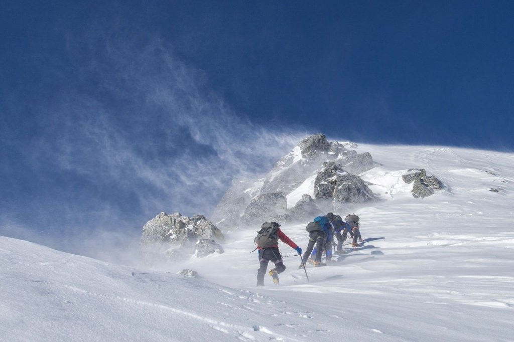 personnes pratiquant l'alpinisme dans la neige